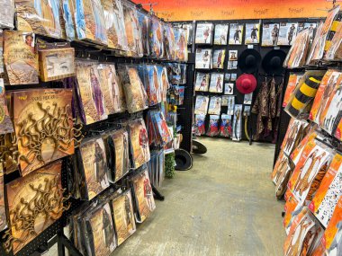 Woodinville, WA USA, 4 Ağustos 2025 - Cadılar Bayramı eşyaları, maskeler, kostümler, iskeletler, figürler, şapkalar, kafatasları, kemikler, mezar taşları olan vitrinler. Cadılar Bayramı konsepti. Dikey fotoğraf