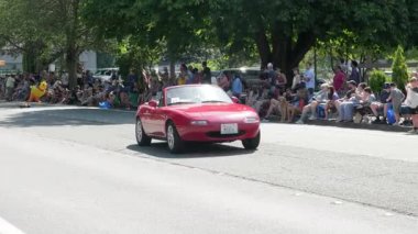 Woodinville, August 9, 2025 - City Day, parade on Main Street, vintage red car driving down the street 