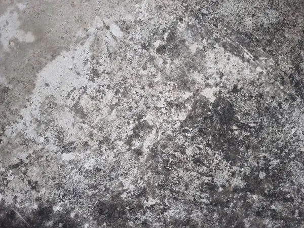 Karanlık ve aydınlık alanları olan kirli beton bir doku.
