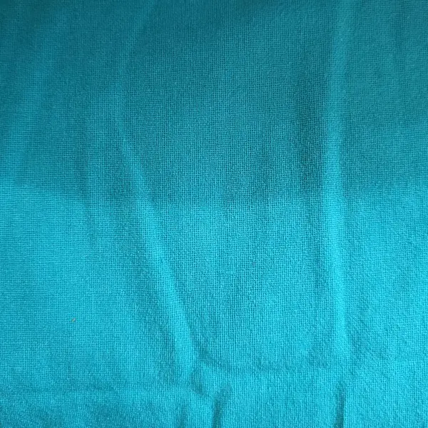 Pürüzsüz bir turkuaz kumaşın katları ve ince gölgeleri var.