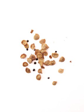 Beyaz bir yüzeyde dağınık domates tohumları ve biberlerin yakın plan çekimi.