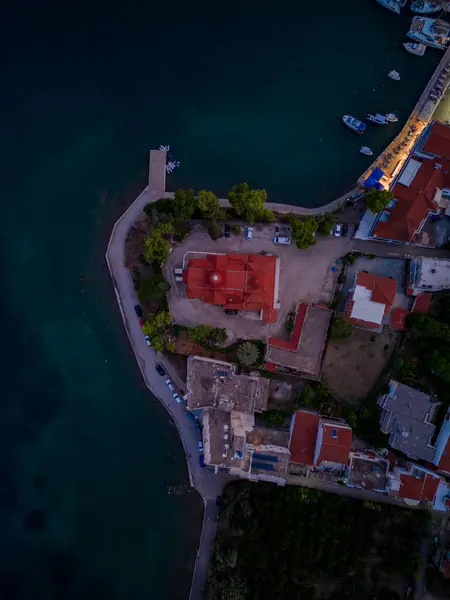 Yunan bir kilisenin tepeden aşağı insansız hava aracı görüntüsü. Plaj, mavi su ve güzel renkler.