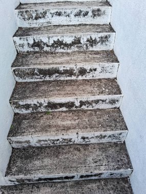 An old open air cement staircase. Stone, cement steps of an old staircase with traces of weathering and destruction. An ancient cement staircase.dirty white cement steps or stairs with mud and water. clipart