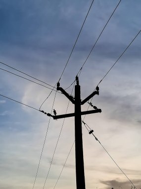 Elektrik direği ve gökyüzünün altındaki halat teli.