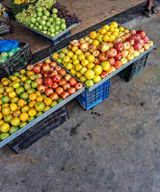Açık hava pazarında canlı bir taze meyve gösterisi. İçi elma, nar, turunçgil, guava ve üzüm dolu sandıklar müşteriler için renkli ve sağlıklı bir seçim olanağı sağlıyor..