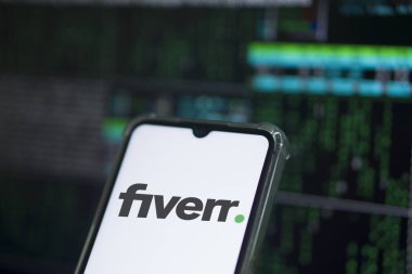 Fiverr logosu bir akıllı telefonda sergileniyor. Şirketin adı Bangladeş, Dhaka 'dan geliyor. 14 Mart 2024.
