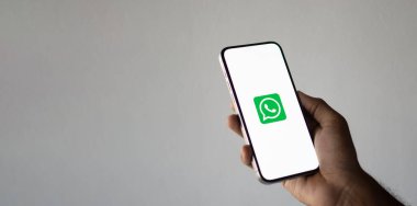 Ekranda WhatsApp ile cep telefonu tutan adam. Dhaka, Bangladeş - 09 Eylül 2024.