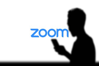 Dhaka, Bangladeş 11 Kasım 2024: Arkaplanda Zoom toplantısı yaparken akıllı telefon ekranında Zoom App logosu.