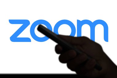 Dhaka, Bangladeş 11 Kasım 2024: Arkaplanda Zoom toplantısı yaparken akıllı telefon ekranında Zoom App logosu.