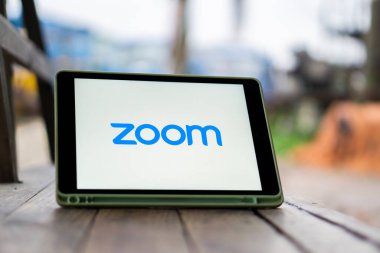 Dhaka, Bangladeş 11 Kasım 2024: Arkaplanda Zoom toplantısı yaparken akıllı telefon ekranında Zoom App logosu.