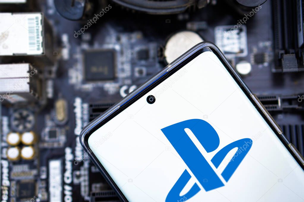 Person holding cellphone with logo of video gaming platform PlayStation Network (PSN) in front of  cihp .