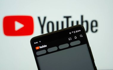 Dhaka, Bangladeş 22 Şubat 2025: YouTube akıllı telefondan açılıyor, Youtube logosu arka planda görülüyor. 