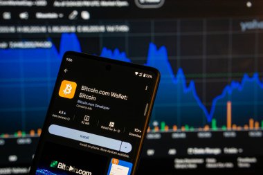 Dhaka, Bangladeş 08 Mart 2025: Bir akıllı telefon üzerindeki Bitcoin Cüzdan uygulaması kurulum ekranı ve arka plandaki finans piyasası grafiği.