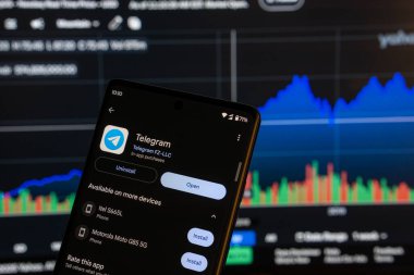 Dhaka, Bangladeş 08 Mart 2025: Akıllı telefondaki telgraf uygulaması kurulum ekranı ve arka plandaki finans piyasası grafiği.