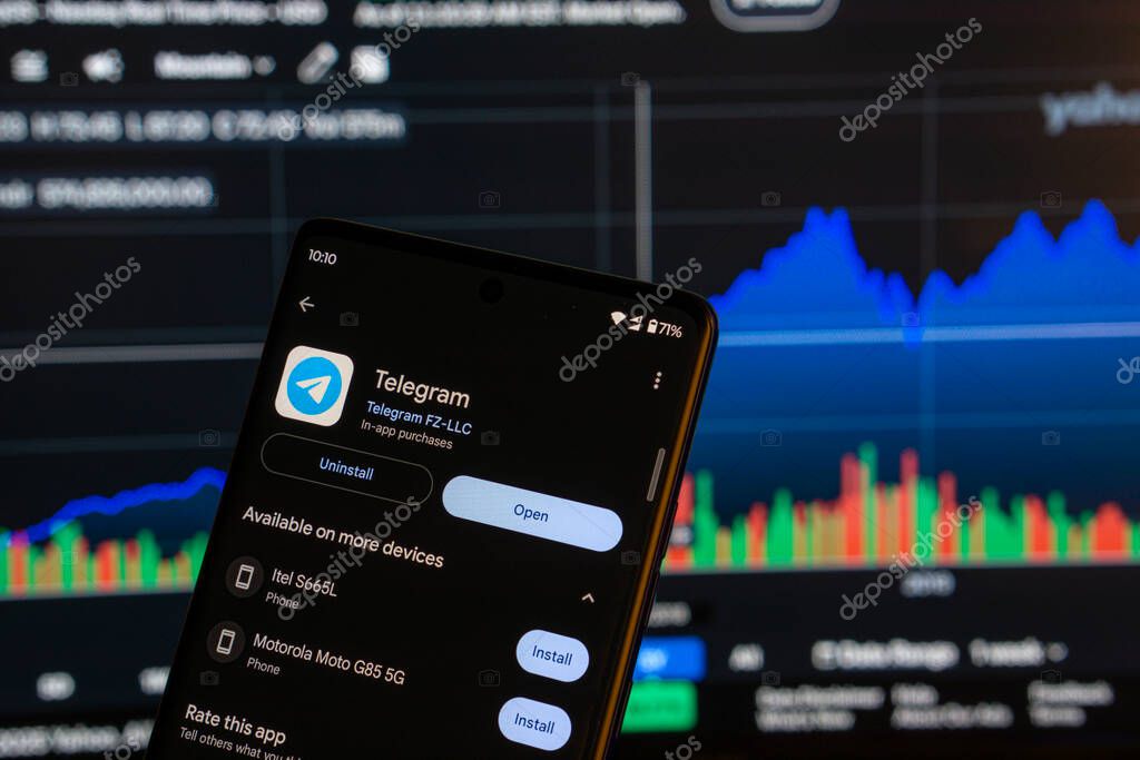 Dhaka,Bangladesh 08 March 2025: Telegram app  installation screen on a smartphone and the financial market chart in the background.