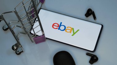 Dhaka, Bangladeş 19 Nisan 2025: eBay online alışveriş, açık artırma ve pazar hizmetleri sunan bir e-ticaret şirketidir. Ekranda eBay logosu olan akıllı telefon, alışveriş arabası. .