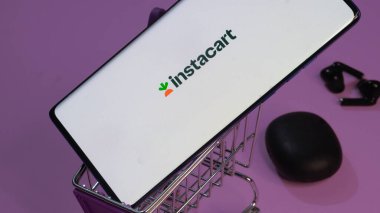 Dhaka, Bangladeş 19 Nisan 2025: ABD 'li perakende şirketi Maplebear Inc' in web sayfası ile cep telefonu tutan kişi logo ile ekranda..