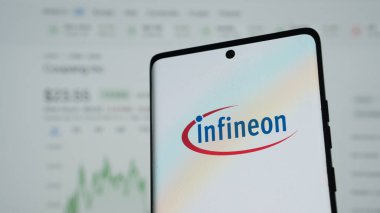 Dhaka, Bangladeş 04 Mayıs 2025: Infineon logosuna sahip akıllı telefon, iş sitelerini ve hizmetlerini çevrimiçi gösteren bir monitör önünde.