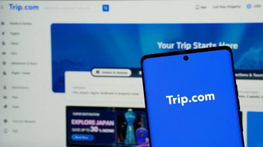 Dhaka, Bangladeş 02 Mayıs 2025: Çinli seyahat şirketi Trip.com Group Limited 'in web sitesi ile cep telefonu logonun önünde ekranda. Telefon ekranının soluna odaklan. Değiştirilmemiş fotoğraf.