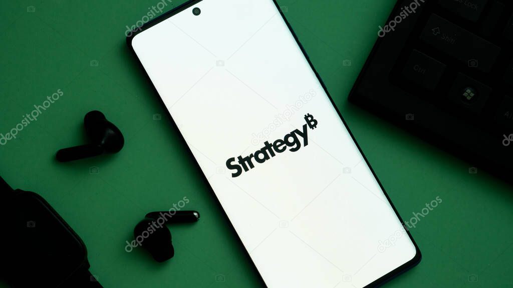 Dhaka, Bangladesh 24 May 2025:Smartphone displaying the word 'Strategy' on a green background with earphones nearby.