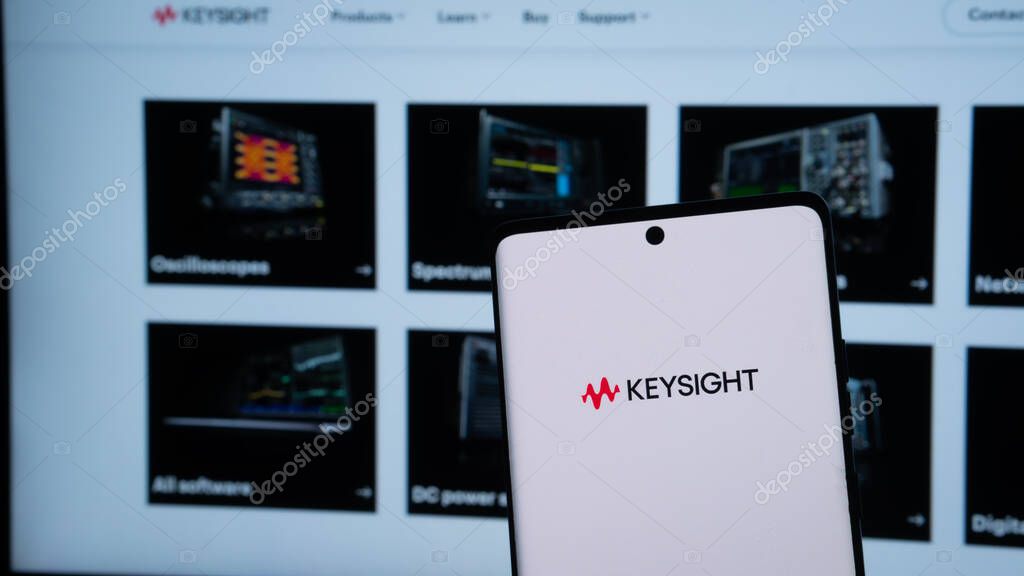 Dhaka, Bangladesh 20 May 2025:Keysight logo displayed on a smartphone with electronic equipment in the background.