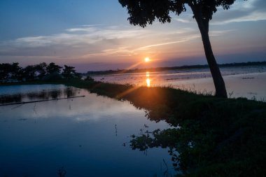 Derin yansımalarıyla gölün üzerinde çarpıcı bir günbatımı.