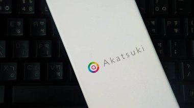 Dhaka, Bangladesh 01 June 2025:Close-up of a smartphone with the Akatsuki logo on a keyboard background.