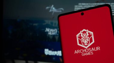 Dhaka, Bangladesh 01 June 2025:Smartphone with Archosaur Games logo against a digital screen.