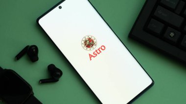 Dhaka, Bangladeş 01 Haziran 2025: Astro akıllı telefondan yeşil kulaklıklı bir logo.