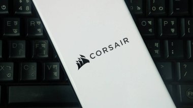 Dhaka, Bangladeş 02 Haziran 2025: CORSAIR logosuna sahip beyaz aygıt bir klavye zeminine yerleştirildi.