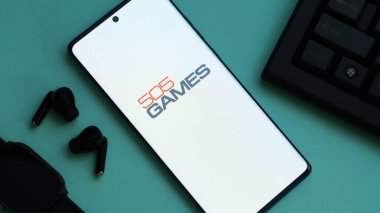 Dhaka, Bangladeş 30 Mayıs 2025: 505 Akıllı telefon logosu ve yeşil yüzey üzerinde klavye.