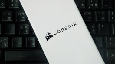 Dhaka, Bangladeş 02 Haziran 2025: CORSAIR logosuna sahip beyaz aygıt bir klavye zeminine yerleştirildi.