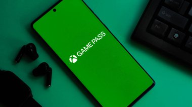 Dhaka, Bangladeş 04 Temmuz 2025: GAME PASS logosunu klavyede yeşil estetik ile gösteren akıllı telefon, modern oyun titreşimlerini iletiyor.