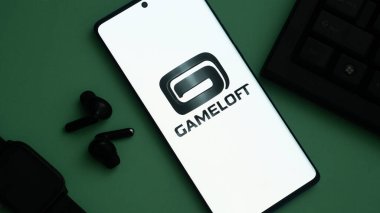 Dhaka, Bangladeş 04 Temmuz 2025: Gameloft logosu, kulaklıklar ve yeşil zemin üzerinde akıllı bir arama gösteren akıllı telefon