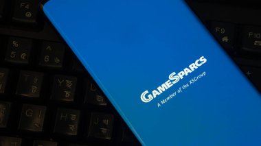 Dhaka, Bangladeş 04 Temmuz 2025: GameSparcs logosu mavi zemin üzerinde klavye tuşları görünür