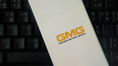 Dhaka, Bangladeş 04 Temmuz 2025: Telefon siyah klavyenin üzerinde GMG logosunu gösteriyor, gösterişli ve minimalist bir stil sergiliyor