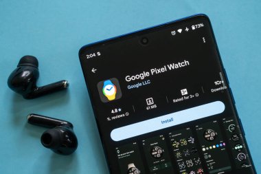 Dhaka, Bangladeş 23 Ağustos 2025: Google Piksel Saati uygulamasının yer aldığı akıllı telefon yakındaki kulaklıklar ile birlikte yükleme sayfası