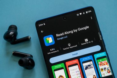 Dhaka, Bangladeş 23 Ağustos 2025: Kulaklıkların yanında ekran yükle Google uygulamasının Read Along ile akıllı telefon