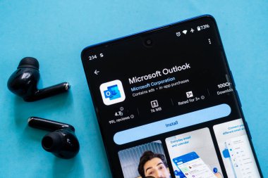 Dhaka, Bangladeş 23 Ağustos 2025: Microsoft Outlook uygulama indirme sayfası akıllı telefondan kulaklıklarla birlikte görüntülendi