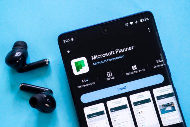 Dhaka, Bangladeş 23 Ağustos 2025: Microsoft Planner uygulamalı akıllı telefon mavi kulaklıklarda siyah kulaklıklar ile birlikte sergilendi