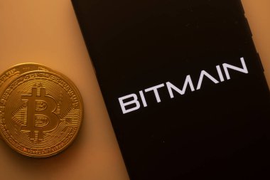 Dhaka, Bangladeş 22 Eylül 2025: Bitcoin Bitmain logosunu gösteren bir akıllı telefonun yanına yerleştirildi