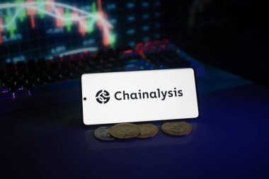 Dhaka, Bangladeş 18 Eylül 2025: Telefondaki zincir analizi logosu, madeni paralar ve hisse senedi şeması eşliğinde dijital finansmanı vurguluyor