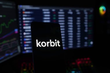 Dhaka, Bangladeş 18 Eylül 2025: Korbit 'i bozuk para ve pazar grafiği yakınında gösteren cep telefonu, kripto para ticareti öneriyor
