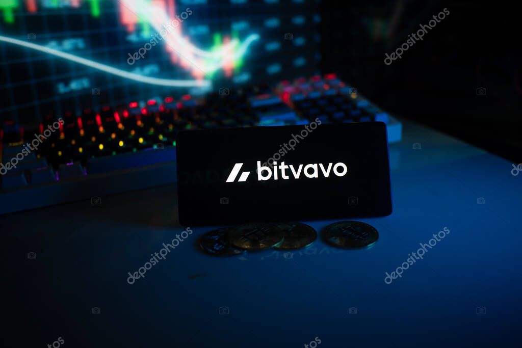 Dhaka, Bangladesh 18 September 2025:Bitvavo display with coins in front of a lit stock chart in blue neon ambiance
