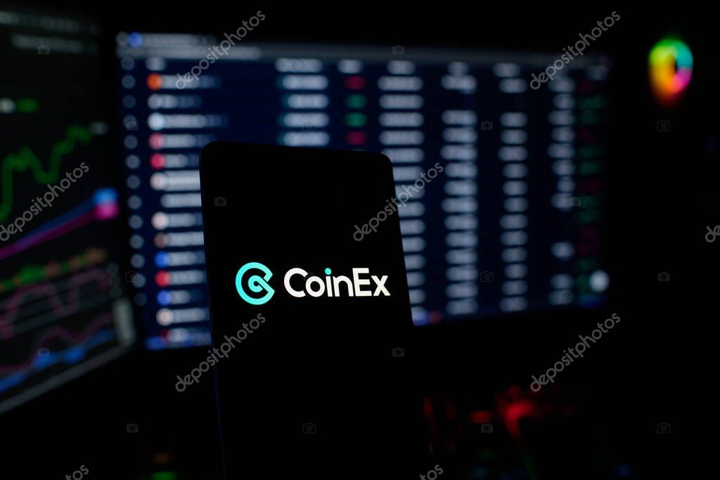 Dhaka, Bangladesh 26 September 2025:CoinEx logo on a smartphone, trading screens visible behind