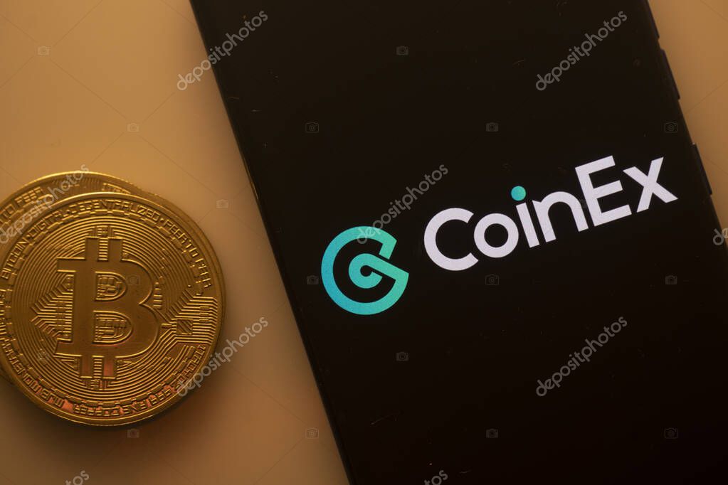 Dhaka, Bangladesh 22 September 2025:CoinEx logo displayed on a smartphone screen near a Bitcoin coin on an orange background