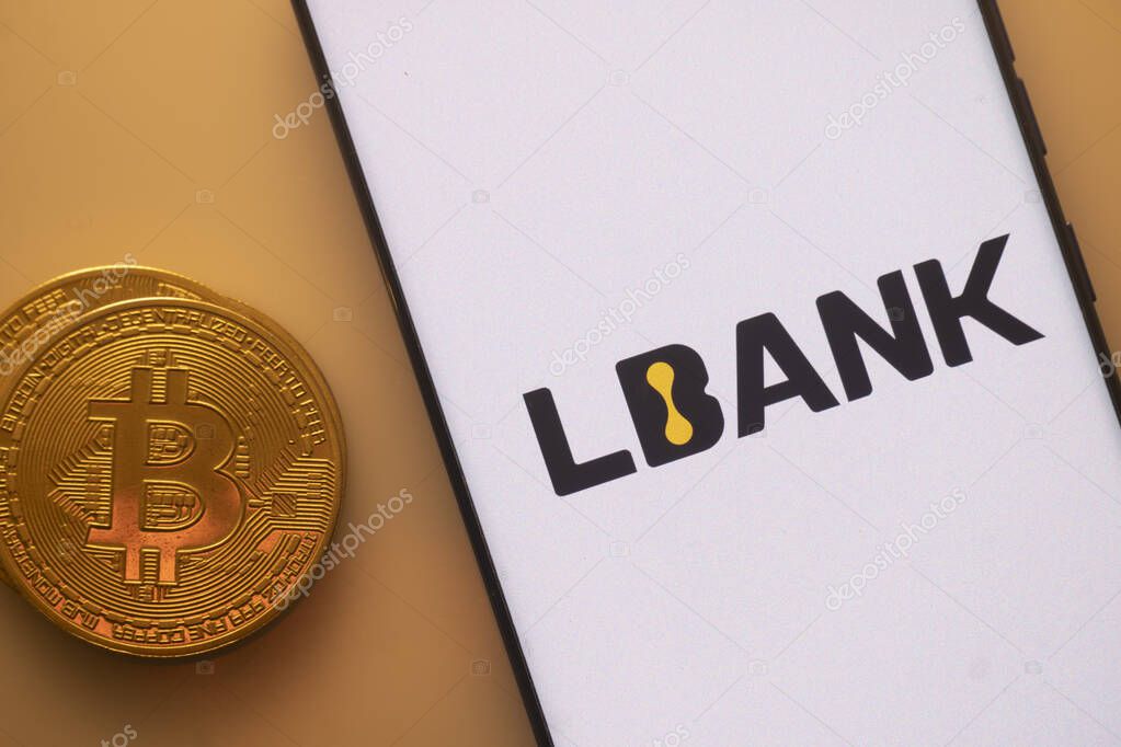 Dhaka, Bangladesh 22 September 2025:Bitcoin coin next to a phone with LBank logo on white screen