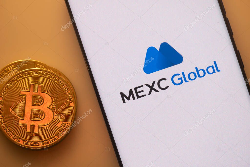 Dhaka, Bangladesh 22 September 2025:Bitcoin coin with a smartphone displaying the MEXC Global logo on a light background