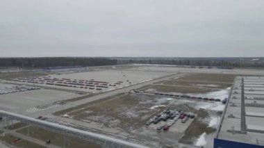 Yeni arabalar üretim tesisinin dışındaki otoparkta eşit olarak dizildi. Drone 'daki kamera yavaşça yukarı doğru hareket ediyor. Yüksek kalite 4k görüntü