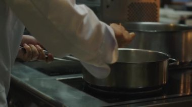 Aşçı sosu kızartma tavasında tutuşturmak için bir gaz tüpü kullanır ve bir alev yaratır. Yüksek kalite 4k görüntü